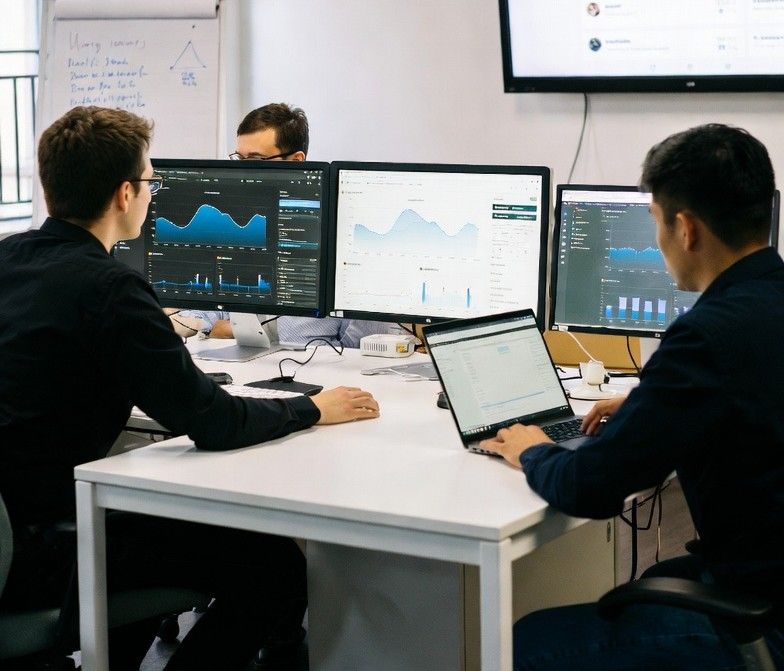 startup team analyzing social media engagement data on multiple screens